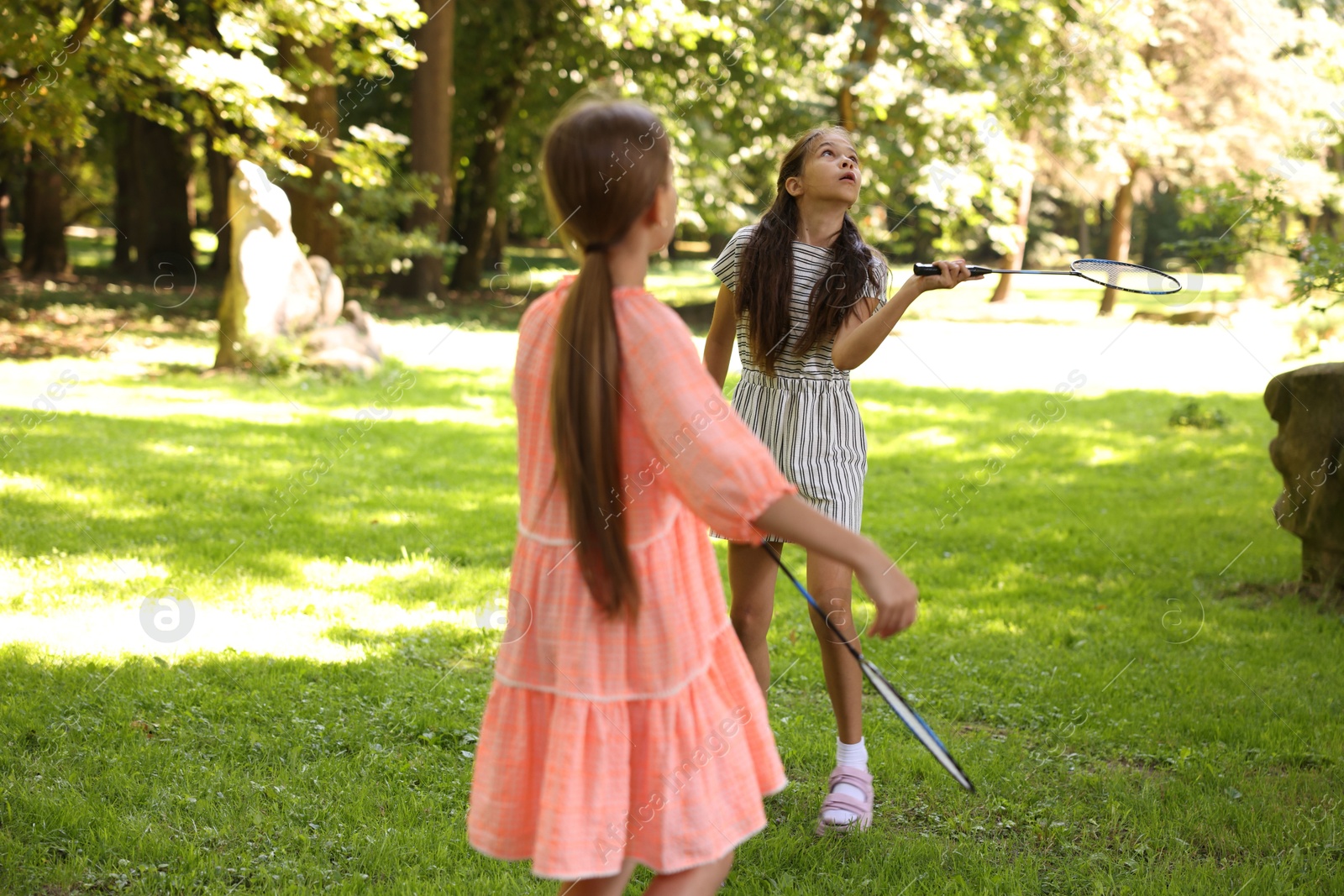 Cute little girls playing badminton in park, selective focus Photo of Cute little girls playing badminton in park, selective focus