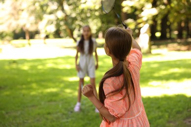 Photo of Cute little girls playing badminton in park, selective focus