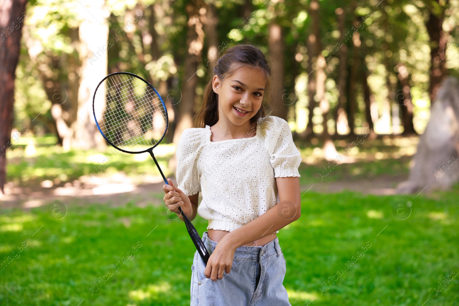 Portrait of smiling little girl with badminton racket in park Photo of Portrait of smiling little girl with badminton racket in park