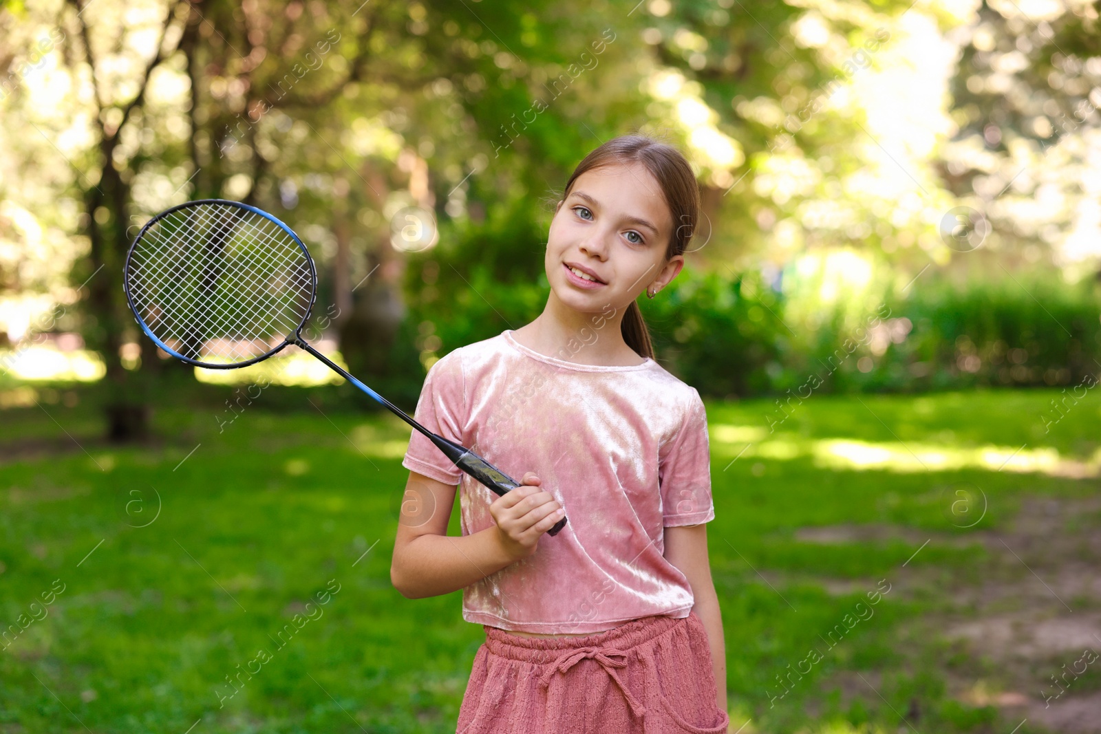 Portrait of smiling little girl with badminton racket in park Photo of Portrait of smiling little girl with badminton racket in park