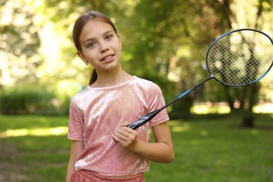Photo of Portrait of smiling little girl with badminton racket in park
