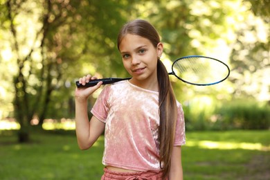 Photo of Portrait of smiling little girl with badminton racket in park