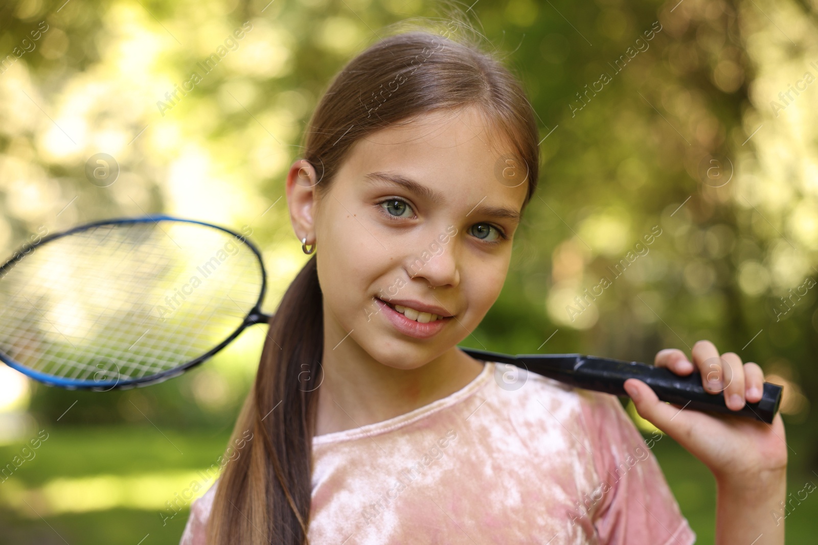 Portrait of smiling little girl with badminton racket in park Photo of Portrait of smiling little girl with badminton racket in park