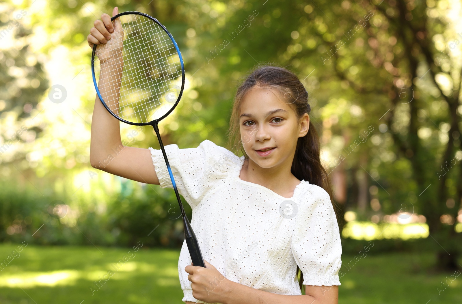 Portrait of smiling little girl with badminton racket in park Photo of Portrait of smiling little girl with badminton racket in park