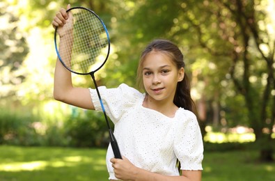 Photo of Portrait of smiling little girl with badminton racket in park