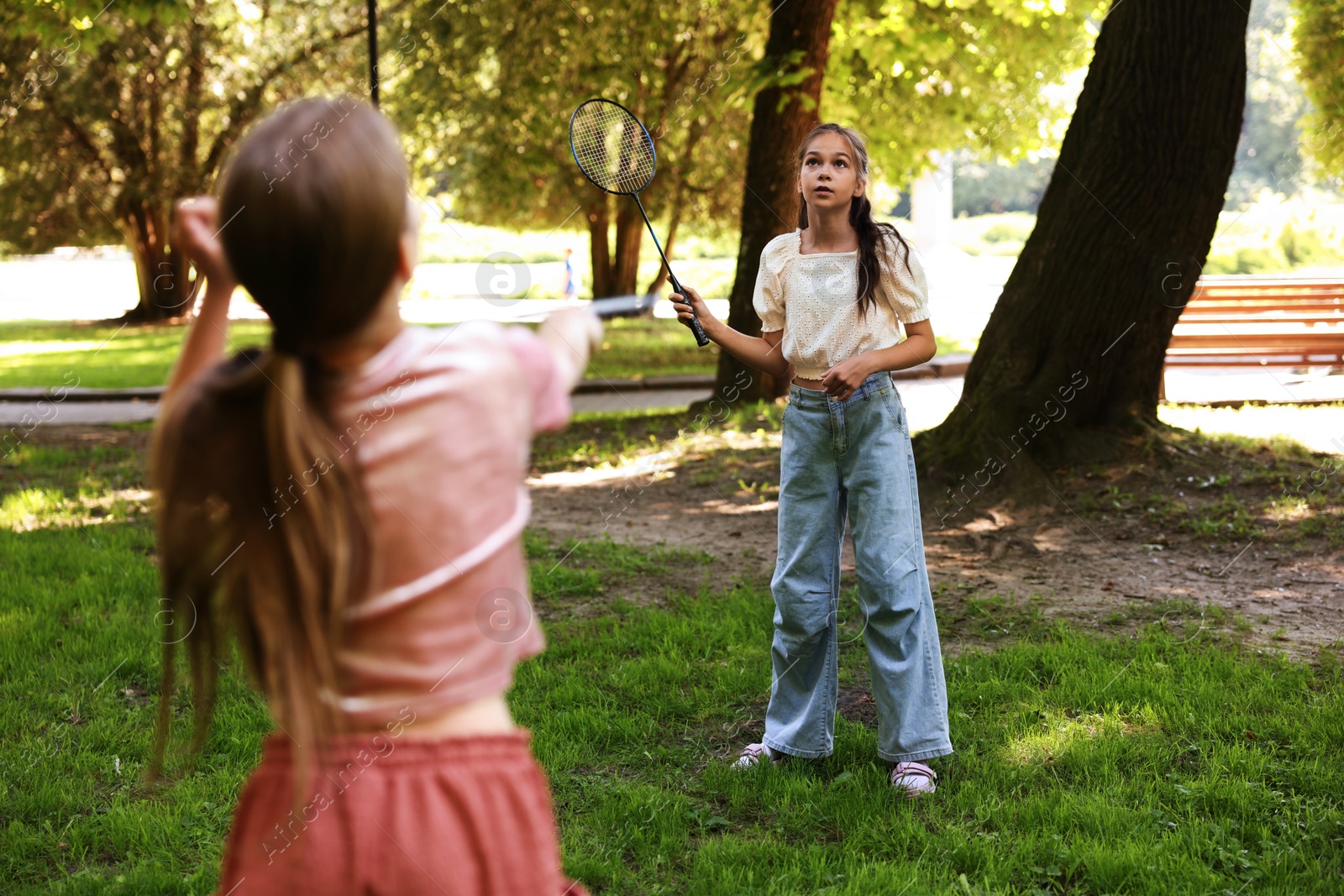 Cute little girls playing badminton in park, selective focus Photo of Cute little girls playing badminton in park, selective focus