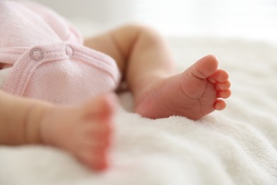 Photo of Cute newborn baby lying on bed, closeup