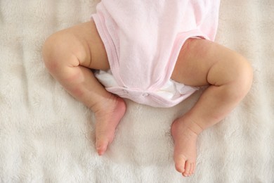 Photo of Cute newborn baby lying on bed, top view
