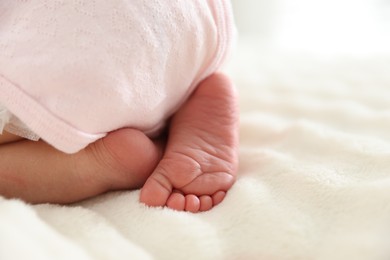 Photo of Cute newborn baby lying on bed, closeup. Space for text