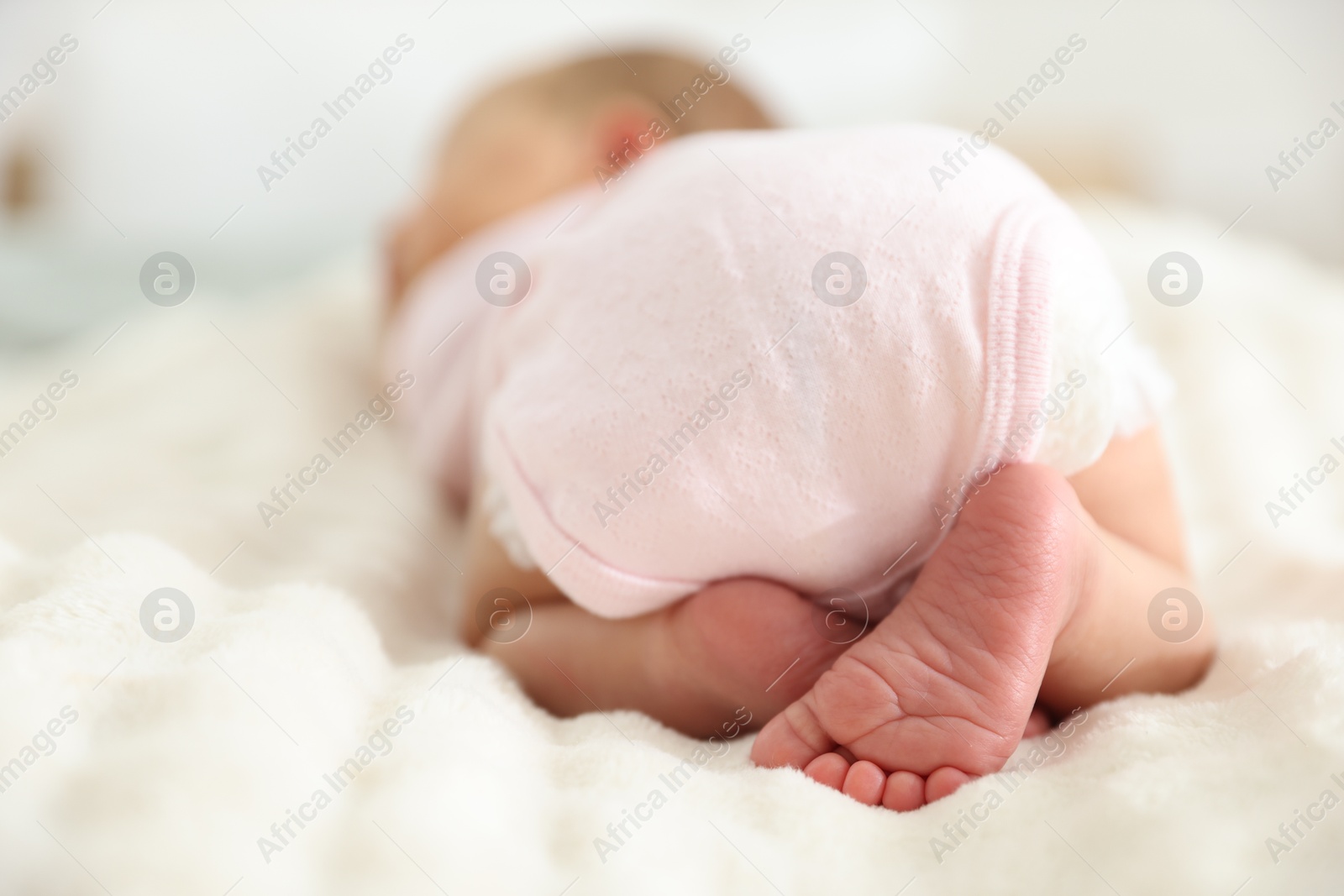 Cute newborn baby lying on bed, closeup Photo of Cute newborn baby lying on bed, closeup