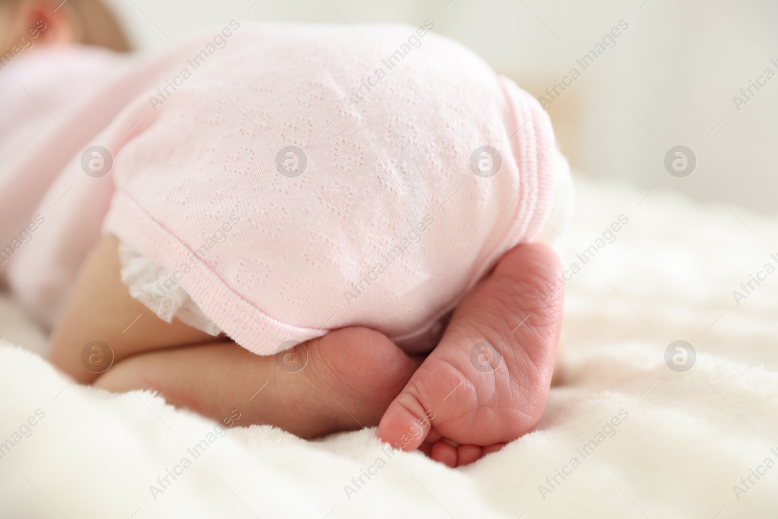 Cute newborn baby lying on bed, closeup Photo of Cute newborn baby lying on bed, closeup