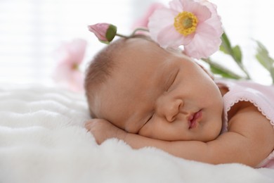 Photo of Cute newborn baby sleeping on bed and flowers indoors