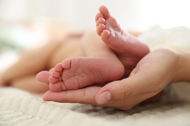 Photo of Mother with her cute newborn baby on bed indoors, closeup