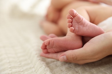 Photo of Mother with her cute newborn baby on bed indoors, closeup. Space for text