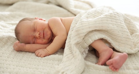 Photo of Cute newborn baby sleeping on bed indoors