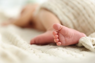 Photo of Cute newborn baby lying on bed indoors, closeup. Space for text