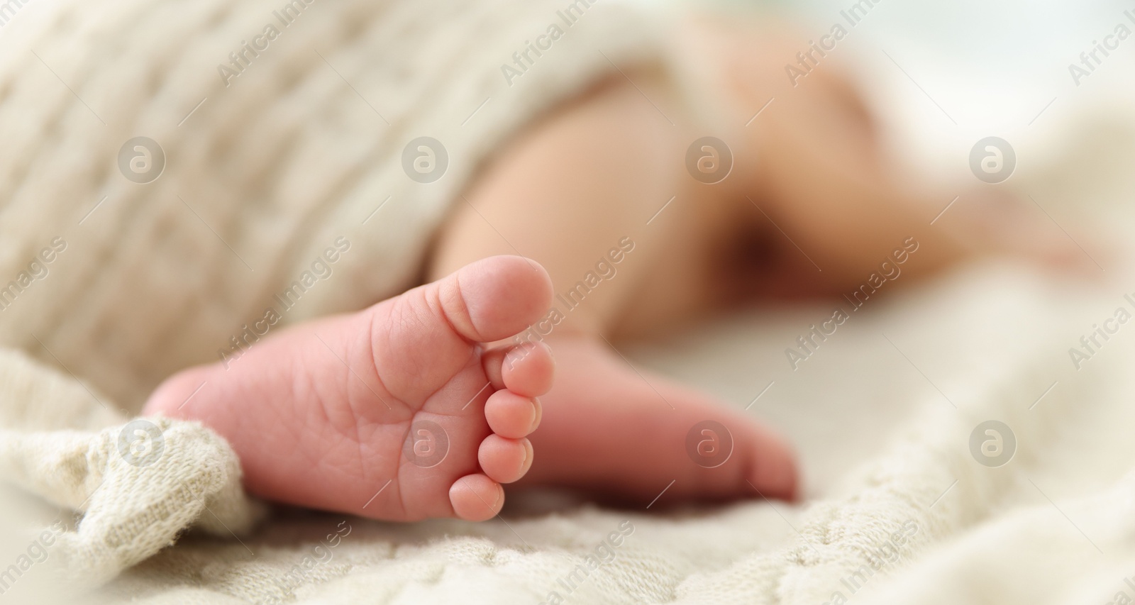 Cute newborn baby lying on bed indoors, closeup. Space for text Photo of Cute newborn baby lying on bed indoors, closeup. Space for text