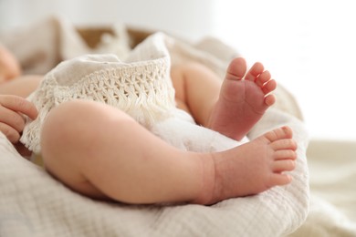 Photo of Cute newborn child lying in baby nest indoors, closeup