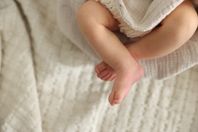 Photo of Cute newborn child lying in baby nest on bed, top view. Space for text