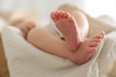 Photo of Cute newborn child lying in baby nest indoors, closeup