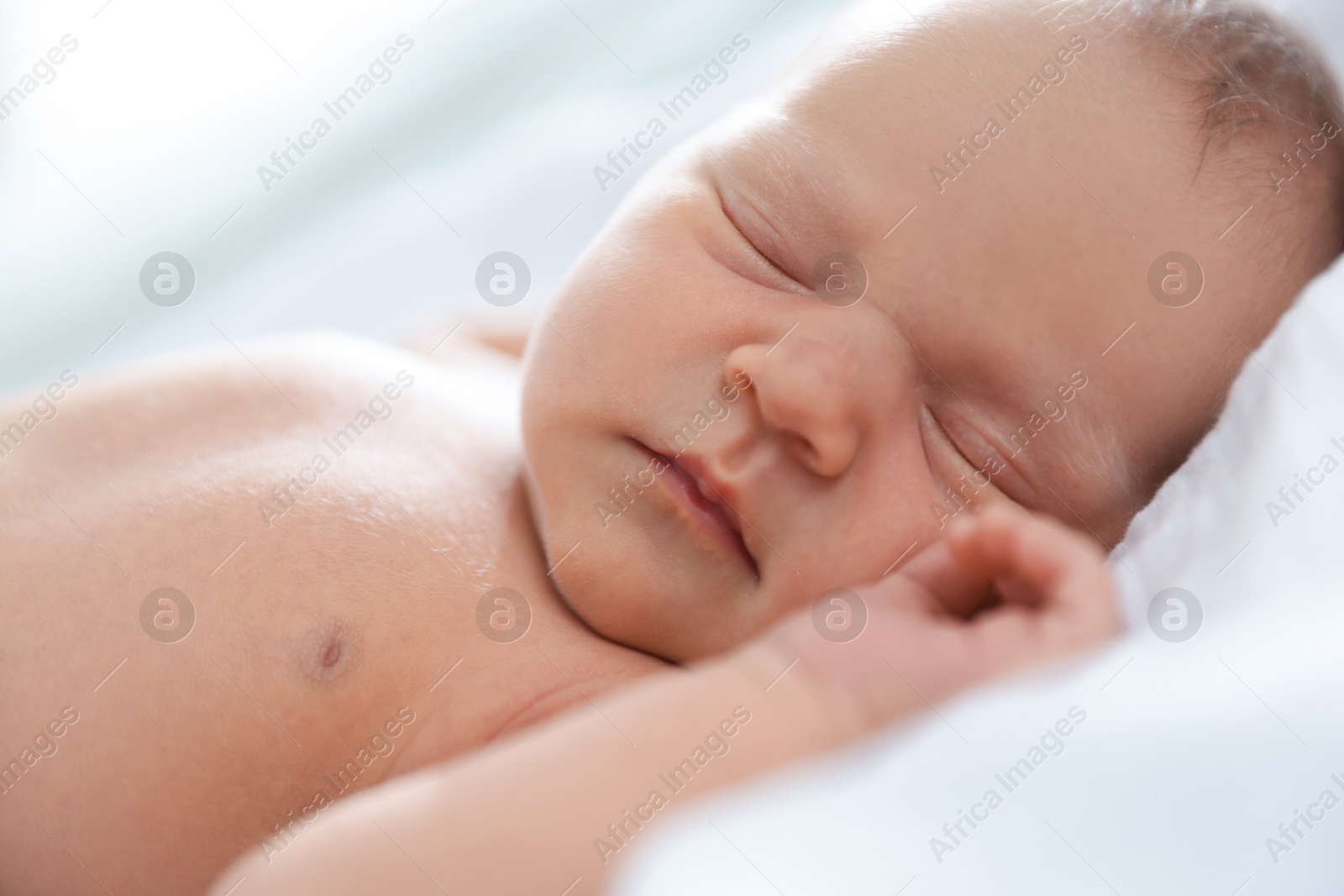Cute newborn baby sleeping on bed indoors Photo of Cute newborn baby sleeping on bed indoors