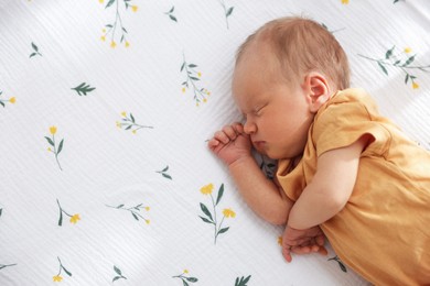 Photo of Cute newborn baby lying in crib, above view. Space for text