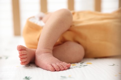 Photo of Cute newborn baby lying in crib, closeup