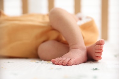 Photo of Cute newborn baby lying in crib, closeup