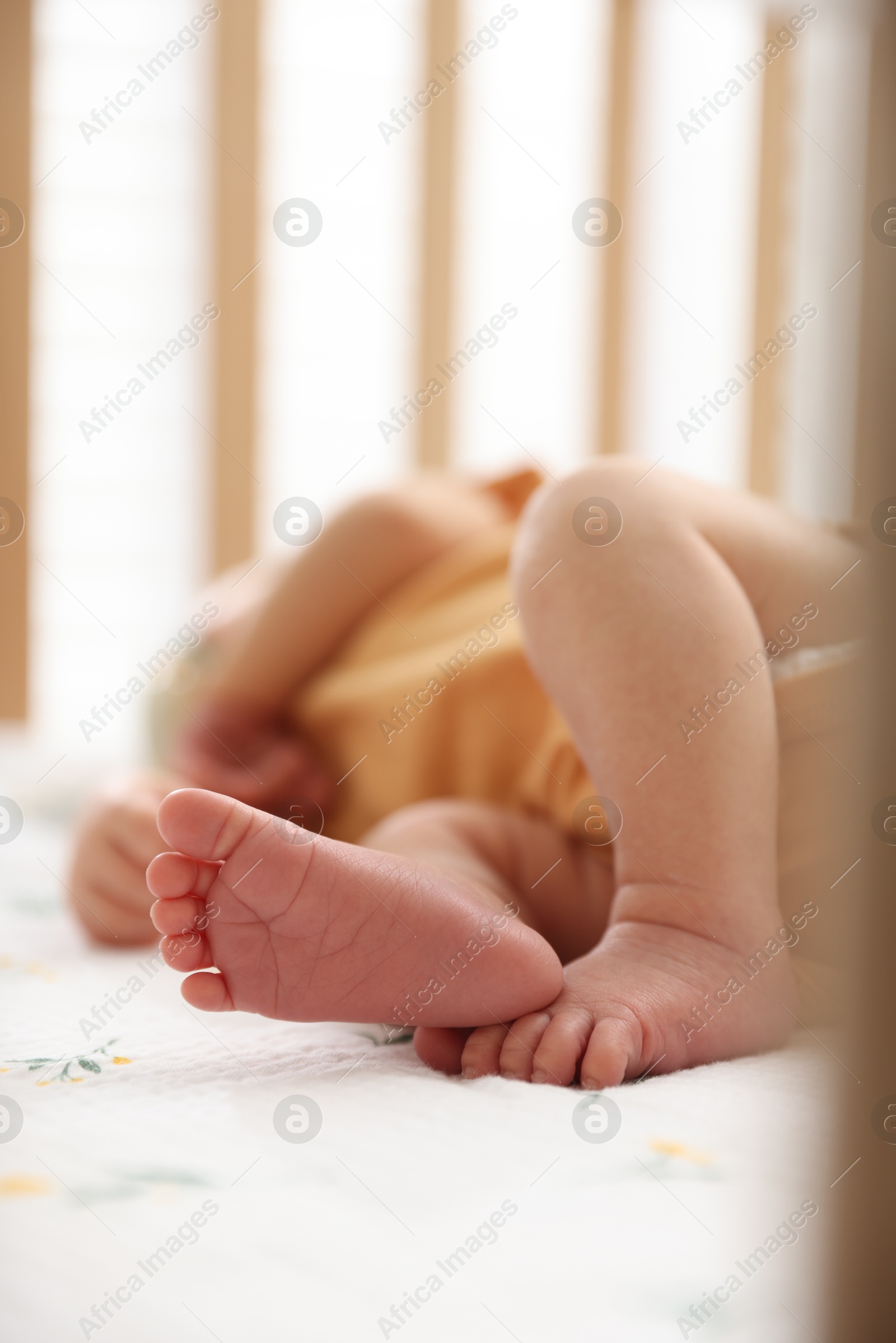 Cute newborn baby lying in crib, closeup Photo of Cute newborn baby lying in crib, closeup
