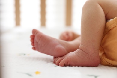 Photo of Cute newborn baby lying in crib, closeup