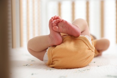 Photo of Cute newborn baby lying in crib, closeup