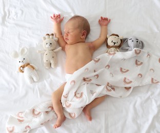 Photo of Cute newborn baby and different toys on bed, top view