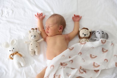 Photo of Cute newborn baby and different toys on bed, top view