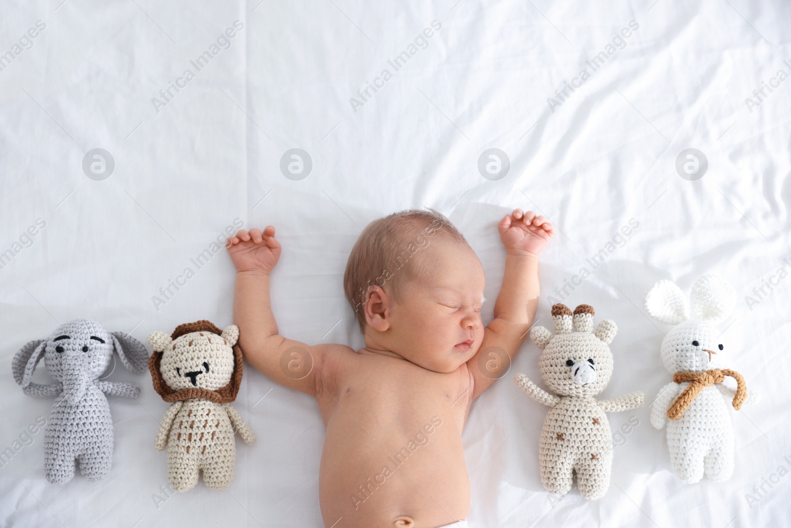 Cute newborn baby and different toys on bed, top view Photo of Cute newborn baby and different toys on bed, top view