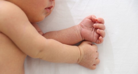 Photo of Cute newborn baby lying on bed, top view