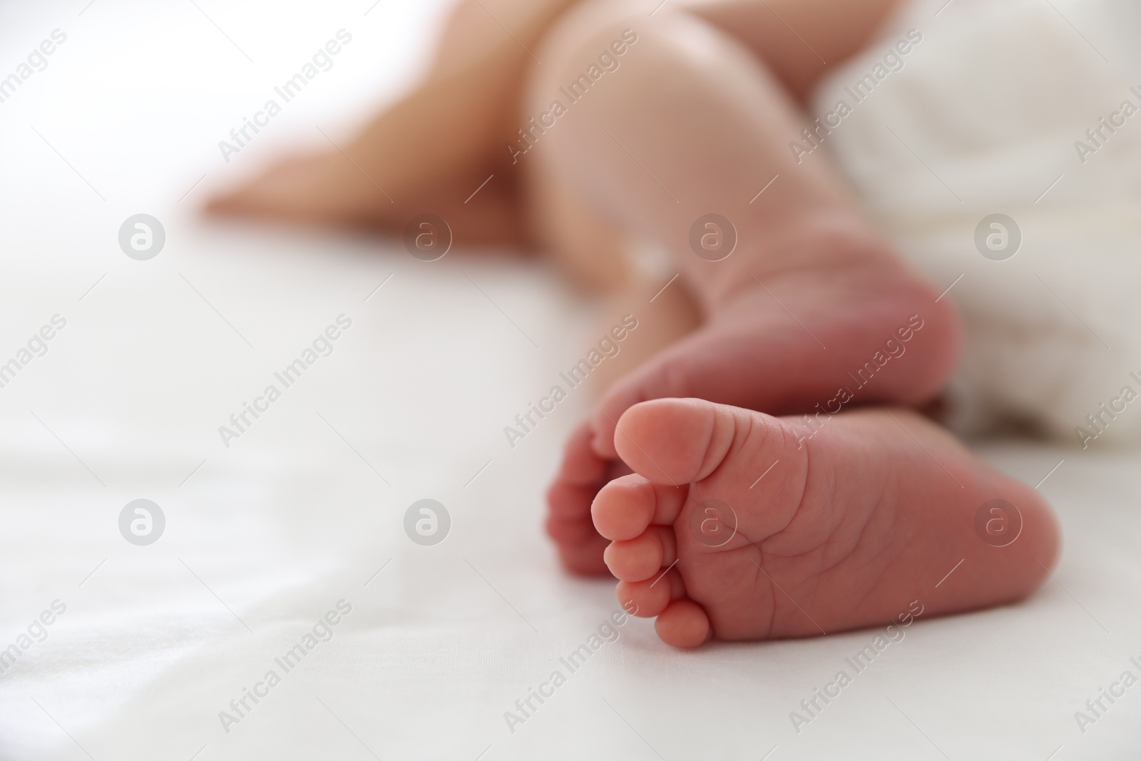 Cute newborn baby lying on bed, closeup. Space for text Photo of Cute newborn baby lying on bed, closeup. Space for text