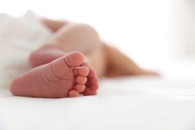 Photo of Cute newborn baby lying on bed, closeup. Space for text