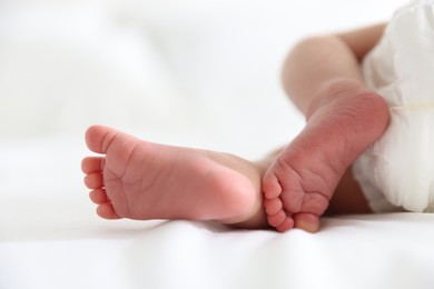 Photo of Cute newborn baby lying on bed, closeup