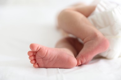 Photo of Cute newborn baby lying on bed, closeup