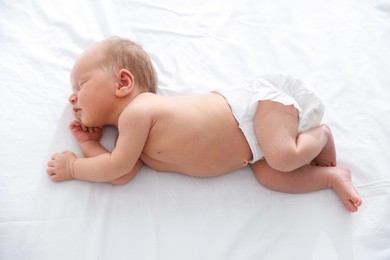 Photo of Cute newborn baby sleeping on bed, above view