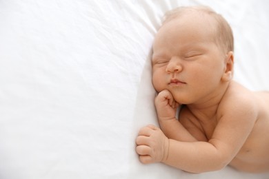 Photo of Cute newborn baby sleeping on bed, space for text