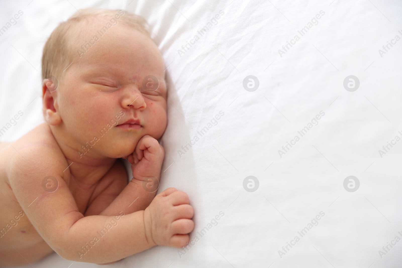 Cute newborn baby sleeping on bed, space for text Photo of Cute newborn baby sleeping on bed, space for text