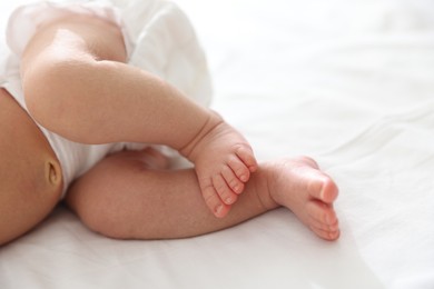 Photo of Cute newborn baby lying on bed, closeup