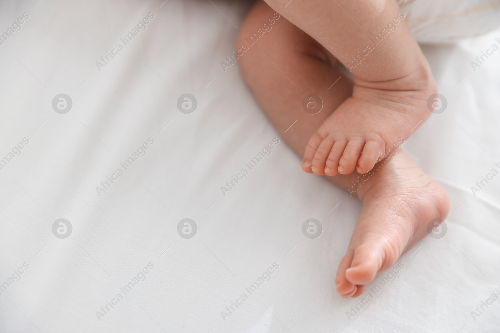 Cute newborn baby lying on bed, above view. Space for text Photo of Cute newborn baby lying on bed, above view. Space for text