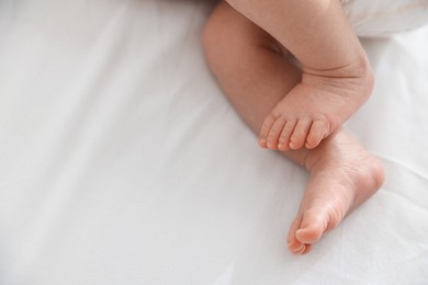 Photo of Cute newborn baby lying on bed, above view. Space for text