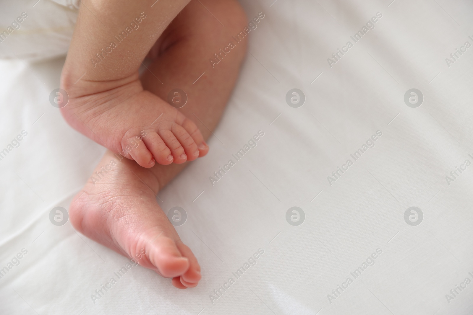 Cute newborn baby lying on bed, above view. Space for text Photo of Cute newborn baby lying on bed, above view. Space for text