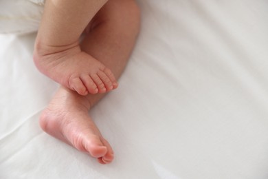 Photo of Cute newborn baby lying on bed, above view. Space for text