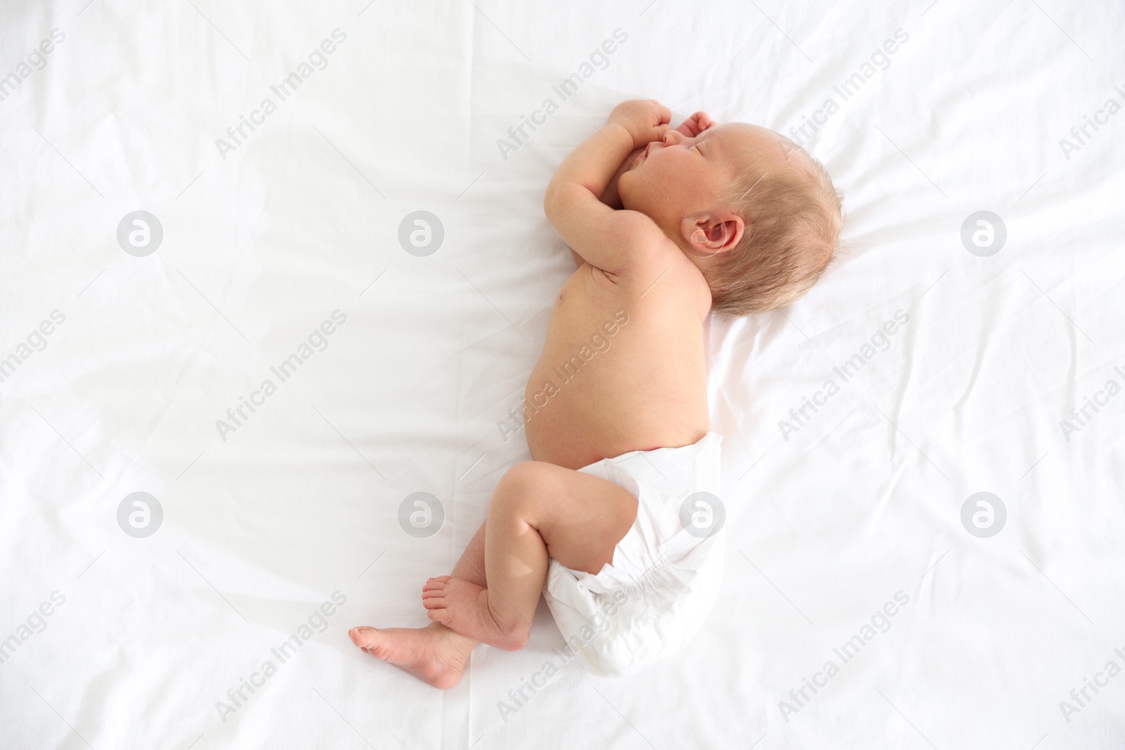 Cute newborn baby sleeping on bed, top view Photo of Cute newborn baby sleeping on bed, top view
