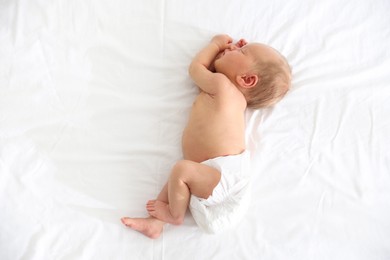 Photo of Cute newborn baby sleeping on bed, top view