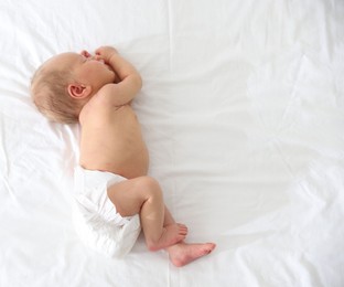 Photo of Cute newborn baby sleeping on bed, top view. Space for text